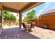 Covered outdoor patio featuring a dining set, lattice screen, and beautiful landscaping at 45424 W Norris Rd, Maricopa, AZ 85139