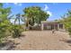 View of the backyard with desert landscaping, gravel, trees, a screened-in patio, and privacy walls at 5529 E Holmes Ave, Mesa, AZ 85206