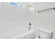 Bright bathroom featuring a white tiled shower and tub combination and a modern toilet at 5529 E Holmes Ave, Mesa, AZ 85206