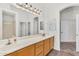 Spacious bathroom featuring double sinks, wood cabinets, a large mirror, and access to other rooms at 5529 E Holmes Ave, Mesa, AZ 85206