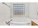 Bright bathroom showcasing a large, inviting soaking tub next to a distinctive glass block window at 5529 E Holmes Ave, Mesa, AZ 85206