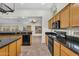 A functional kitchen featuring wooden cabinets, a dark countertop, stainless steel appliances, and tile flooring at 5529 E Holmes Ave, Mesa, AZ 85206