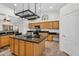 A spacious kitchen with wood cabinets, dark countertops, stainless steel appliances, and tiled flooring at 5529 E Holmes Ave, Mesa, AZ 85206