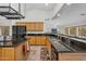 Open concept kitchen with wood cabinets, dark countertops, stainless appliances, and tiled floor at 5529 E Holmes Ave, Mesa, AZ 85206