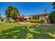 Spacious backyard featuring a covered patio, lush lawn, and mature landscaping, perfect for outdoor living and entertaining at 5613 E Calle Del Paisano --, Phoenix, AZ 85018