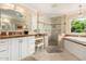 Bright bathroom with a large glass shower, soaking tub, and white vanity with counterspace at 5613 E Calle Del Paisano --, Phoenix, AZ 85018