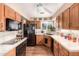 Well-lit kitchen featuring wood cabinets, tile countertops, and modern black appliances at 5613 E Calle Del Paisano --, Phoenix, AZ 85018