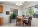 Cozy dining area filled with natural light, featuring a wooden table set and views of the outdoor greenery at 6205 W Encinas Ln, Phoenix, AZ 85043