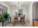 Well-lit dining area with a wooden table set, tile floors and views of the outdoor greenery at 6205 W Encinas Ln, Phoenix, AZ 85043