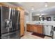 Spacious kitchen with stainless steel appliances, wood cabinetry, and an open layout into the living area at 6205 W Encinas Ln, Phoenix, AZ 85043