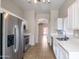 Modern kitchen with stainless steel refrigerator, white cabinetry, and an open view to other rooms at 6610 E University Dr # 163, Mesa, AZ 85205