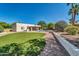 Gorgeous backyard offers a pool, well manicured lawn, lush greenery and a patio area at 6615 E Phelps Rd, Scottsdale, AZ 85254