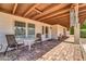 Charming covered patio with stone flooring, cozy seating, and lush backyard views at 6615 E Phelps Rd, Scottsdale, AZ 85254