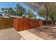Backyard fence and sidewalk featuring lush trees, rock landscaping and exterior walls at 6711 W Osborn Rd # 82, Phoenix, AZ 85033