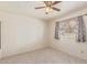This cozy bedroom features soft carpet, a ceiling fan, and a window with natural light at 6711 W Osborn Rd # 82, Phoenix, AZ 85033