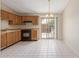 Bright kitchen features tile flooring, wood cabinets, a black range, and a sliding glass door at 6711 W Osborn Rd # 82, Phoenix, AZ 85033