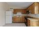 Bright kitchen features tile flooring, wood cabinets, and white refrigerator at 6711 W Osborn Rd # 82, Phoenix, AZ 85033