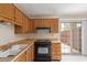 Bright kitchen features tile flooring, wood cabinets, black range and access to backyard at 6711 W Osborn Rd # 82, Phoenix, AZ 85033