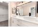 Elegant bathroom featuring double sinks, modern fixtures, large mirror, and walk-in closet at 857 E Impreria St, San Tan Valley, AZ 85140