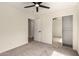 Cozy bedroom with carpet, ceiling fan, closet with mirrored sliding doors and attached bathroom at 857 E Impreria St, San Tan Valley, AZ 85140