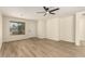 Bright living room with wood-look flooring, a ceiling fan, and a window looking out onto the front yard at 857 E Impreria St, San Tan Valley, AZ 85140