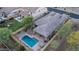 Aerial view showcasing a home with a backyard pool and patio area, complemented by lush desert landscaping at 9037 E Indigo St, Mesa, AZ 85207