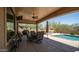 Spacious covered patio featuring outdoor seating and dining area near a pool and well-maintained yard at 9037 E Indigo St, Mesa, AZ 85207