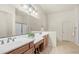 Bright bathroom featuring dual sinks, a large mirror, and a separate glass-enclosed shower at 9037 E Indigo St, Mesa, AZ 85207