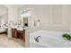Luxurious bathroom with dual sinks, a soaking tub, and a large mirror with decorative lighting at 9037 E Indigo St, Mesa, AZ 85207