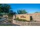 Stone sign welcomes you to Corte Bella, with lush landscaping and blue skies creating a serene entrance at 9037 E Indigo St, Mesa, AZ 85207
