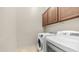 Functional laundry room with modern washer and dryer units and overhead cabinets at 9037 E Indigo St, Mesa, AZ 85207