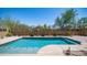 Refreshing pool surrounded by desert landscaping, block fencing, and clear blue skies create a private oasis at 9037 E Indigo St, Mesa, AZ 85207
