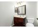 Cozy powder room featuring wood vanity and decorative mirror at 11020 N 154Th Ln, Surprise, AZ 85379