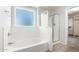 Bright bathroom featuring a soaking tub, shower, and a closet at 11020 N 154Th Ln, Surprise, AZ 85379