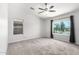 A spacious carpeted bedroom with two windows allowing natural light and a ceiling fan at 11020 N 154Th Ln, Surprise, AZ 85379