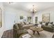 Staged living room featuring wood floors, light walls, and comfortable seating at 11020 N 154Th Ln, Surprise, AZ 85379