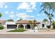 Charming single-story home featuring a black garage door, arched entryway, tile roof, and well-manicured landscaping at 12835 N 78Th St, Scottsdale, AZ 85260