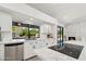 Bright white kitchen featuring modern appliances, a center island cooktop, and a large window overlooking the backyard at 12835 N 78Th St, Scottsdale, AZ 85260