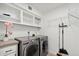 Bright laundry room with modern washer and dryer, shelving, and storage space, offering convenience and organization at 12835 N 78Th St, Scottsdale, AZ 85260