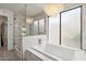 Bright bathroom featuring a tub, shower, and decorative chandelier at 12835 N 78Th St, Scottsdale, AZ 85260