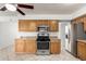 A kitchen featuring wood cabinets, a tile floor, stainless steel appliances, and backyard views at 1545 W 7Th Ave, Mesa, AZ 85202