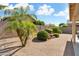 Lush backyard showcasing desert landscaping, mature trees, and a charming rock waterfall feature at 17653 W Ingleside Dr, Surprise, AZ 85374