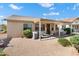 Back exterior featuring a covered patio, desert landscaping, and neutral-toned stucco, blending seamlessly with the neighborhood at 17653 W Ingleside Dr, Surprise, AZ 85374