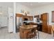 Well-lit kitchen features granite counters, stainless steel appliances, wood cabinets, and a central island with bar seating at 17653 W Ingleside Dr, Surprise, AZ 85374