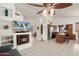 Open-concept living area boasting tile floors, a corner fireplace, a ceiling fan, and seamless access to the kitchen at 17653 W Ingleside Dr, Surprise, AZ 85374