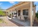 Relaxing covered patio with seating and a grill, perfect for enjoying the landscaped backyard at 17653 W Ingleside Dr, Surprise, AZ 85374