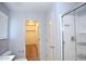 Bathroom featuring a walk-in closet, walk-in shower, and white cabinets at 19889 W Annika Dr, Litchfield Park, AZ 85340