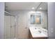 Bright bathroom with a double sink vanity, large mirror, and a glass-enclosed walk-in shower at 19889 W Annika Dr, Litchfield Park, AZ 85340