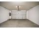 Clean garage featuring a roll-up door, bright lighting, and ample space for vehicles and storage at 19889 W Annika Dr, Litchfield Park, AZ 85340