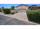 Attached garage with driveway, mature hedges, and a two-car garage at 21017 W Edith Way, Buckeye, AZ 85396